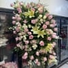 Large standing spray of pink roses and pale lilies