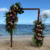 Floral wedding arch decorated with pink and white flowers on a beach