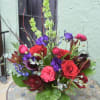 Mixed bouquet with red roses, purple blooms, and dark calla lilies