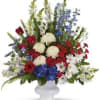 Red, white, and blue floral arrangement in a white vase