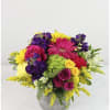 Colorful bouquet of roses, gerbera daisies, and mixed blooms in a gray vase
