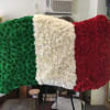 Floral display in green, white, and red arranged like a flag on an easel