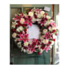 Heart-shaped funeral wreath with pink lilies, red roses, and white flowers