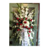 Tall standing floral spray with white flowers and red roses on a ribboned easel