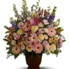 Mixed pink and cream flowers arranged in a brown urn vase