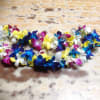 Colorful orchid lei laid on a wooden surface