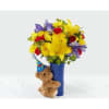 Bright mixed bouquet in a blue vase with a teddy bear attached
