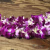 Purple orchid lei on a wooden surface
