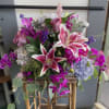 Mixed bouquet with pink lilies, roses, and purple orchids in a basket