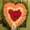 Heart-shaped standing floral spray with red roses and pink carnations