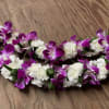 Purple orchid and white carnation floral garlands on a wooden surface