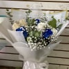 Bouquet of white and blue roses with baby's breath and eucalyptus in white wrap