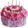 Pink floral cake with lit candles on top