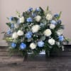 White roses and blue carnations in a low rectangular arrangement