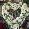 A lush heart-shaped sympathy arrangement that speaks to quiet remembrance, arranged on