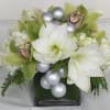 White and green floral arrangement in a square glass vase with silver ornaments