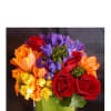 Colorful bouquet of roses, tulips, and purple flowers in a glass vase