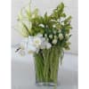 White orchids and green calla lilies in a clear glass vase