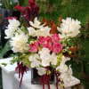 Pink roses and white orchids in a square glass vase
