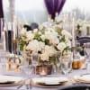 White floral centerpiece with candles on a decorated banquet table