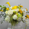 White and yellow floral arrangement in a white vase
