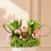 Pink tulips and roses arranged with pink daisies in a clear handbag-style container