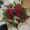 Bouquet of red roses with white filler flowers and greenery in gold-trimmed wrap