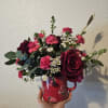 Pink and burgundy flower arrangement in a red mug