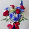 Bouquet of red roses, blue and white daisies, and baby's breath in a blue vase