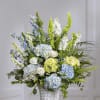 Blue and white floral arrangement in a white wicker basket