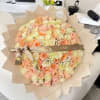 Large bouquet of peach and cream roses wrapped in tan paper with a birthday ribbon