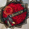 Heart-shaped bouquet of red roses with black wrapping and gold accents
