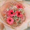 Pink gerbera daisies and roses wrapped in pale peach paper