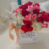Box of red and pink roses with a wine bottle and ribbon