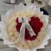 Bouquet of red and white roses wrapped in white paper with a satin bow