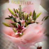 Bouquet of pink and white lilies wrapped in pink paper