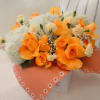 Orange roses and white flowers in a wrapped bouquet