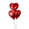 Three red heart-shaped balloons on strings