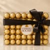 Box of Ferrero Rocher chocolates tied with a black ribbon