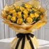 Bouquet of yellow roses wrapped in gold paper with a black ribbon