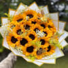 Bouquet of sunflowers wrapped in white and gold paper