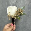 White rose boutonni&egrave;re with gold baby breath and black ribbon.