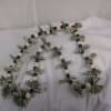 Beaded garland with folded dollar bills on a white cloth