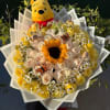 Bouquet of yellow and cream roses with a sunflower and a Winnie the Pooh plush