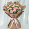 Pink carnation bouquet wrapped in brown paper with a ribbon