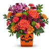 Bouquet of orange and purple flowers in a jack-o'-lantern vase