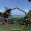 Two large tropical flower designs adorning a circular wedding arch. Circular arch