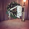 White floral funeral wreath on a stand with a ribbon