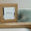 Boxed body and hand soap bar beside a green marbled soap bar