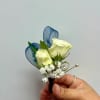White rose boutonniere with blue ribbon loops and baby's breath